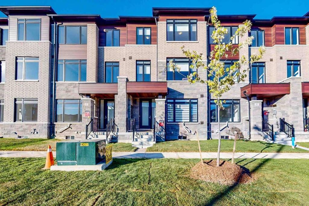 a building with a tree in front of it at NEWLY BUILT LUXURIOUS 3BRM TOWN HS/AIRPORT/PARKING in Brampton