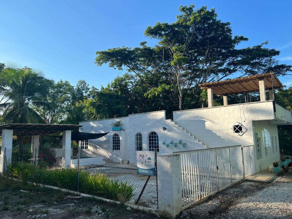 a white house with a gate and a fence at Cabaña Doradal MILOS in Puerto Triunfo