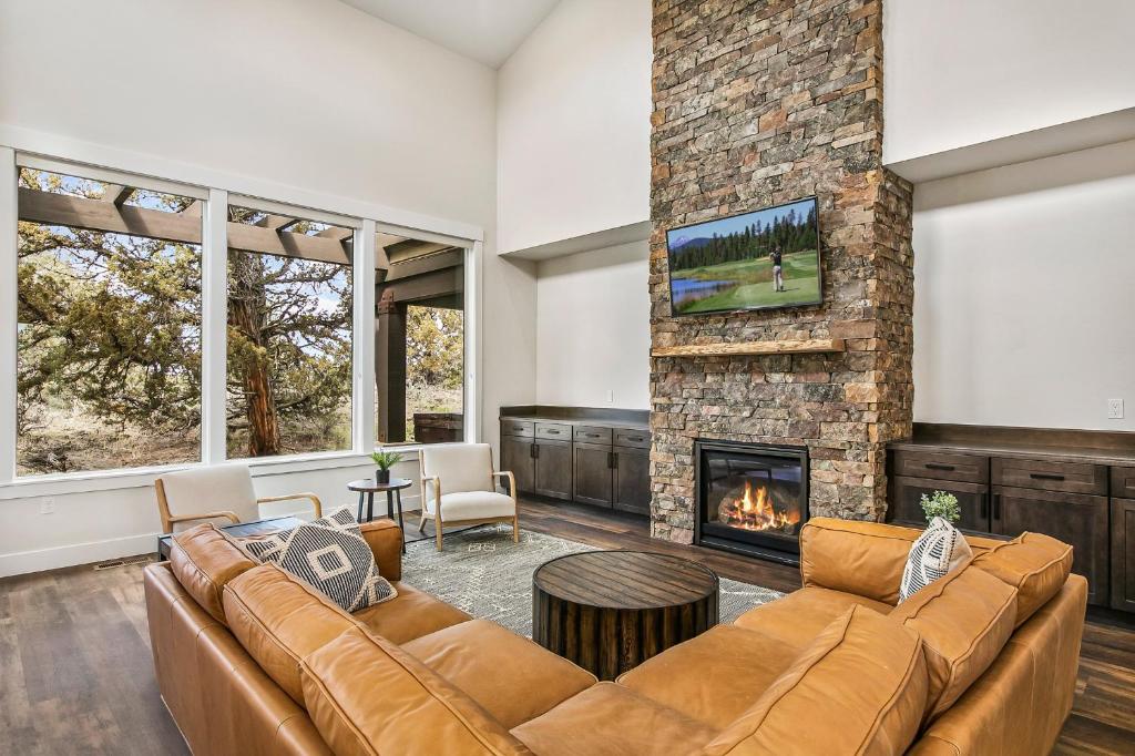 sala de estar con sofá y chimenea en Juniper Ranch House at Brasada Ranch Resort, en Alfalfa