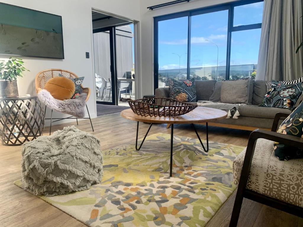 a living room with a couch and a table at SEAduction Luxury Apartment in Napier