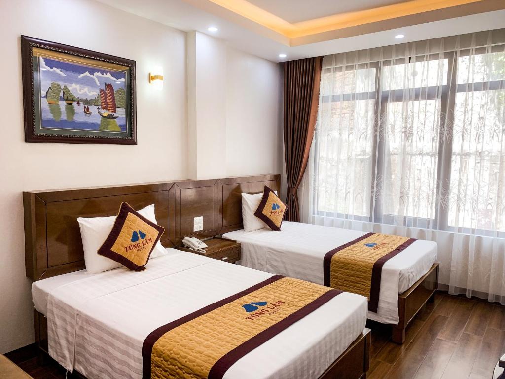ein Hotelzimmer mit zwei Betten und einem Fenster in der Unterkunft TÙNG LÂM HOTEL in Hạ Long