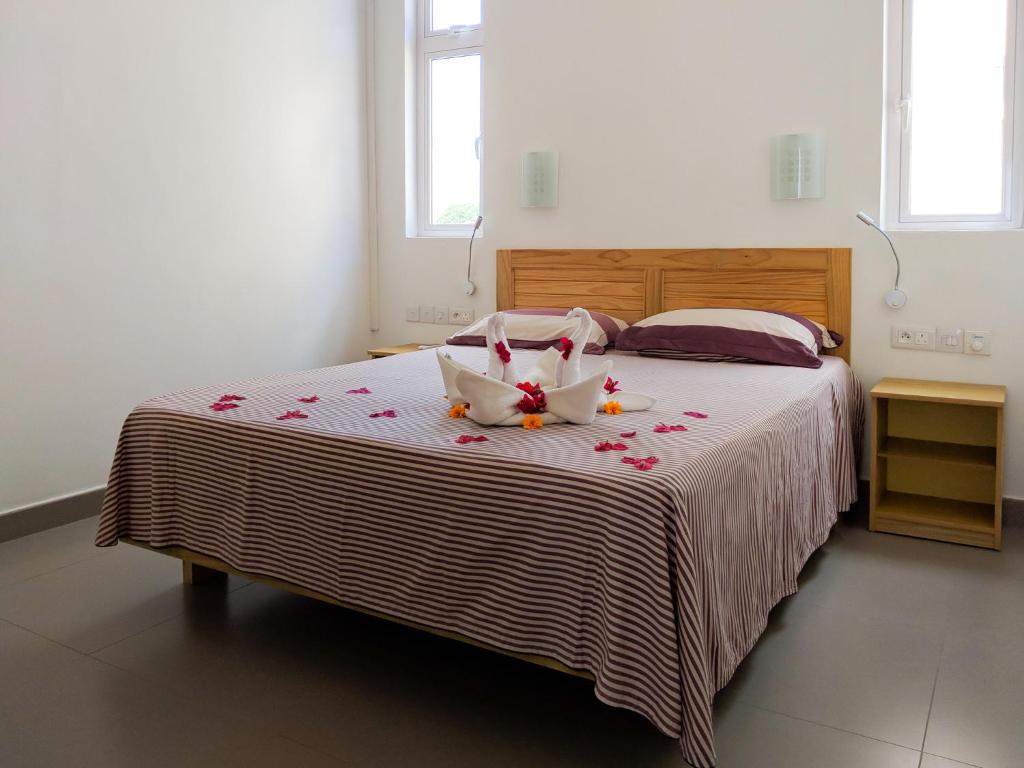 Un dormitorio con una cama con flores. en Villa Alexis - Location de vacances à Trou aux Biches, en Trou aux Biches