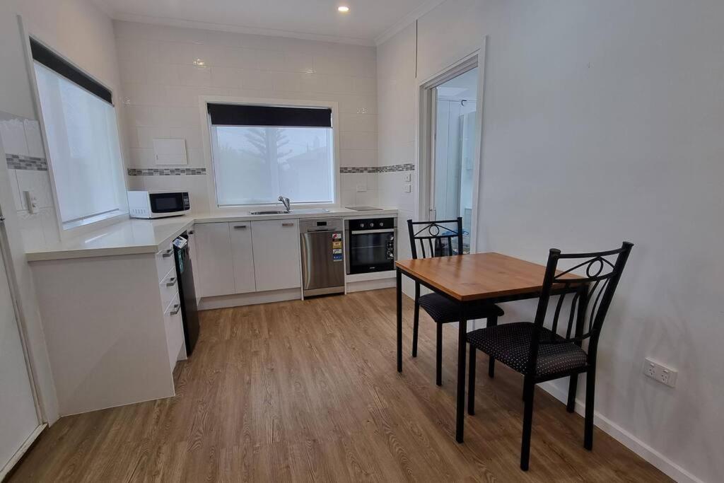 a kitchen with a table and chairs in a room at Modern 1 bedroom studio free parking close to CBD in Burnie