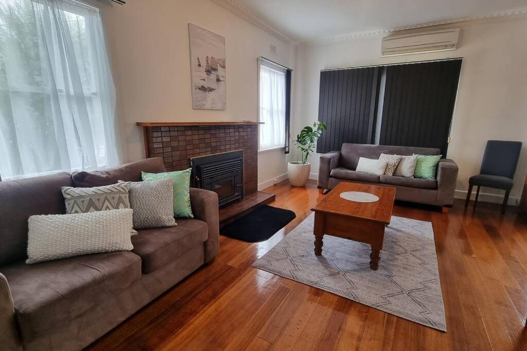 a living room with a couch and a table at 3 bedroom Art Deco home with modern features in Burnie