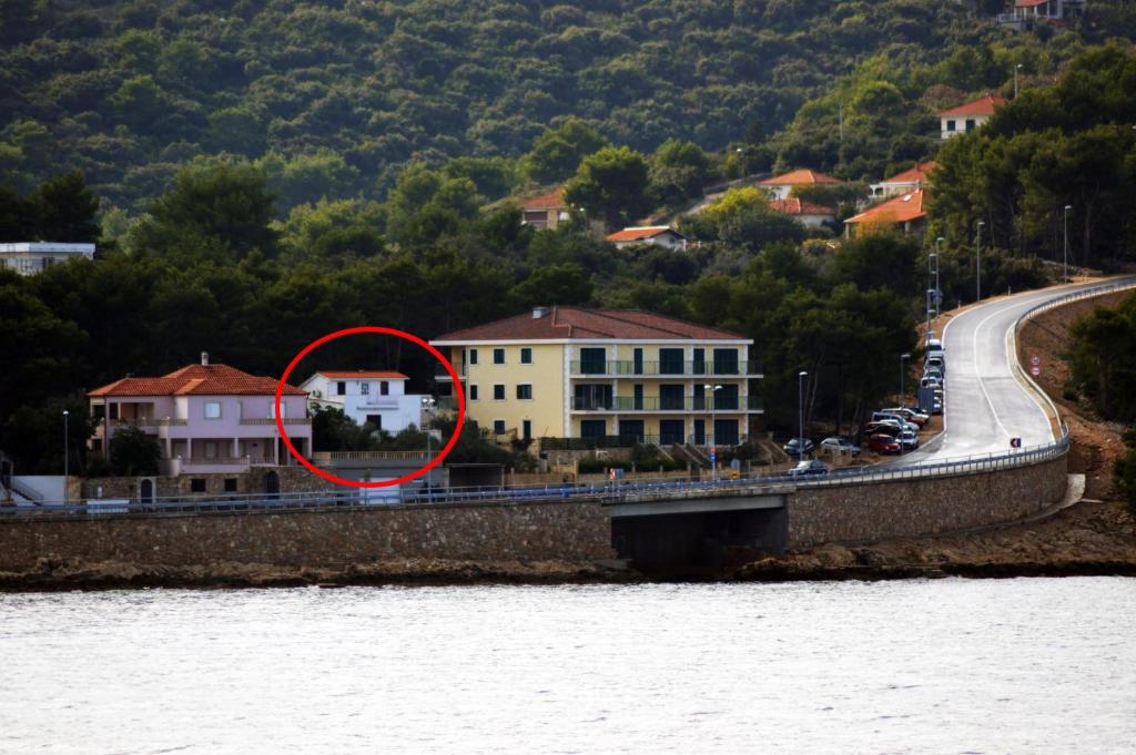 a building with a red circle in front of a bridge at Apartments by the sea Rogac, Solta - 16223 in Grohote