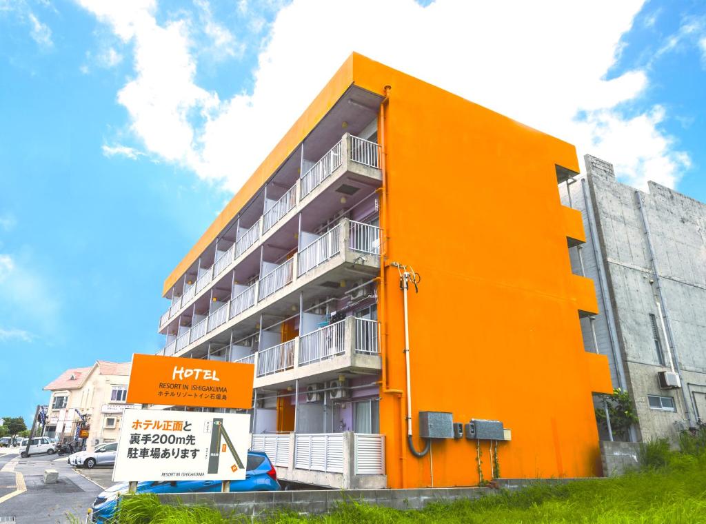 un edificio naranja con un letrero delante de él en Hotel Resort Inn Ishigakijima, en Ishigaki Island