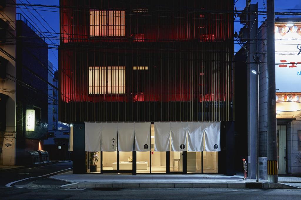 um edifício alto com uma fachada vermelha e branca em THE HOTELS HAKATA Harushige SHINKAN em Fukuoka