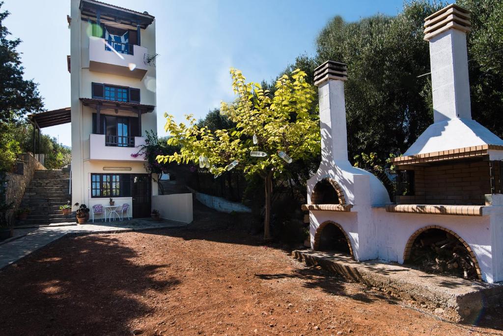 a building next to a dirt road next to a building at Malia budget in Pírgos