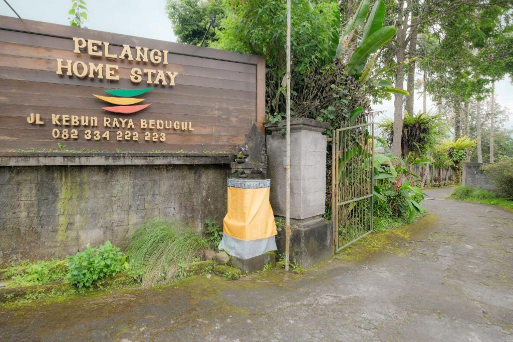 a sign for a home stay next to a building at Pelangi Homestay Bedugul RedPartner in Bedugul