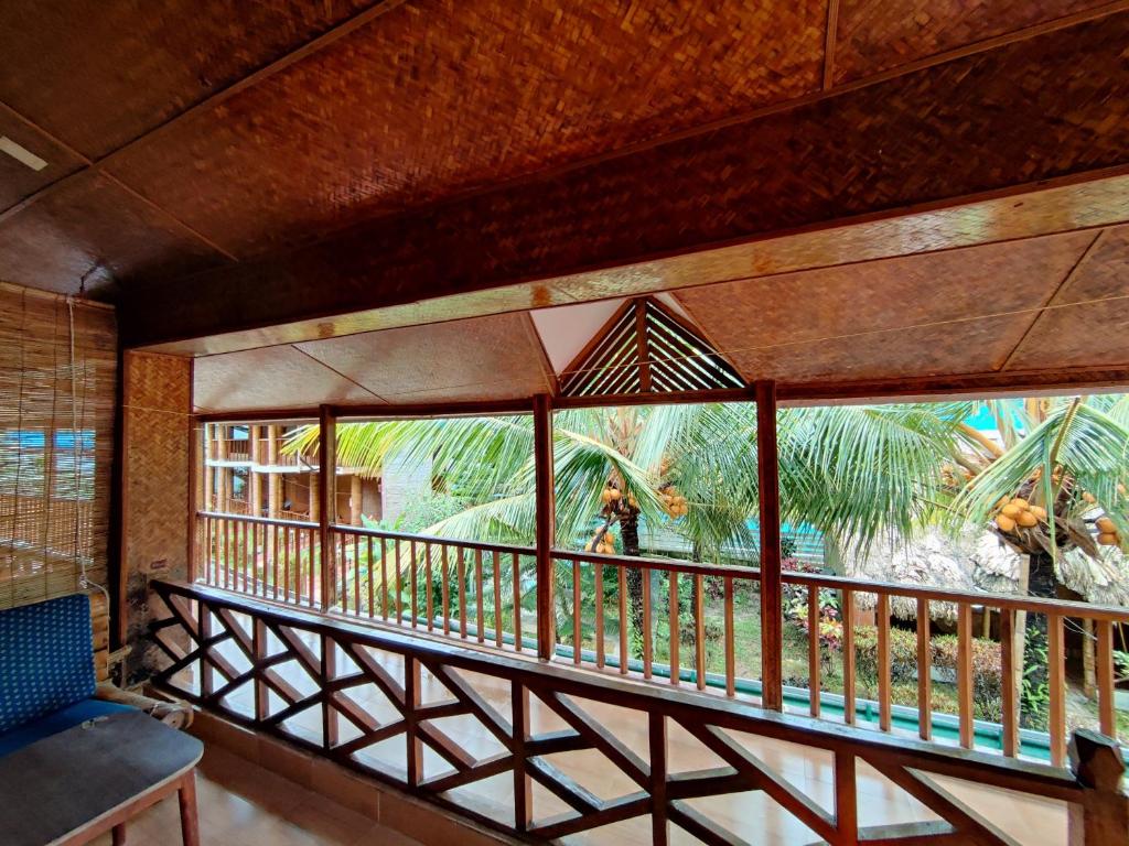 a balcony with a view of a palm tree at Kathmandu Resort in Havelock Island