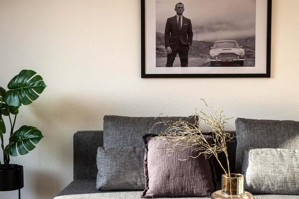 Una foto di un uomo in giacca e cravatta su un muro accanto a un divano di Cozy 4 room apartment in Hilden a Hilden