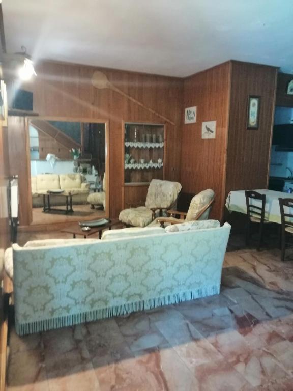 sala de estar con sofá, sillas y mesa en casetta a Pescasseroli le 4 stagioni, en Pescasseroli