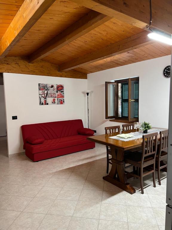a living room with a red couch and a table at Casa Nico in Montemarciano