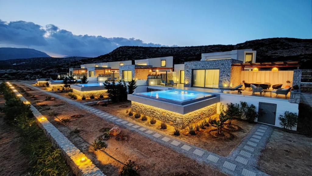 a villa with a swimming pool at night at Aros Luxury Villas in Karpathos