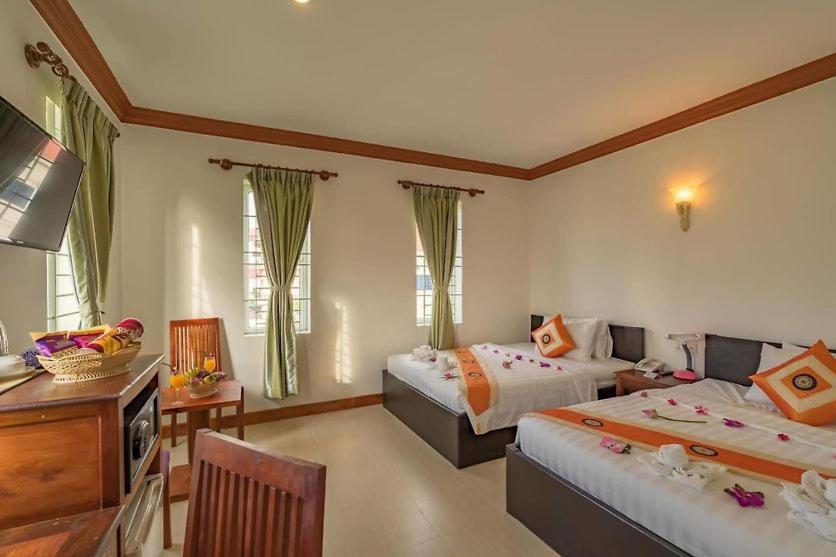 Postel nebo postele na pokoji v ubytování Angkor Leap Hotel