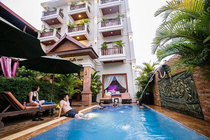 two people sitting in a swimming pool in a hotel at Angkor Leap Hotel in Siem Reap