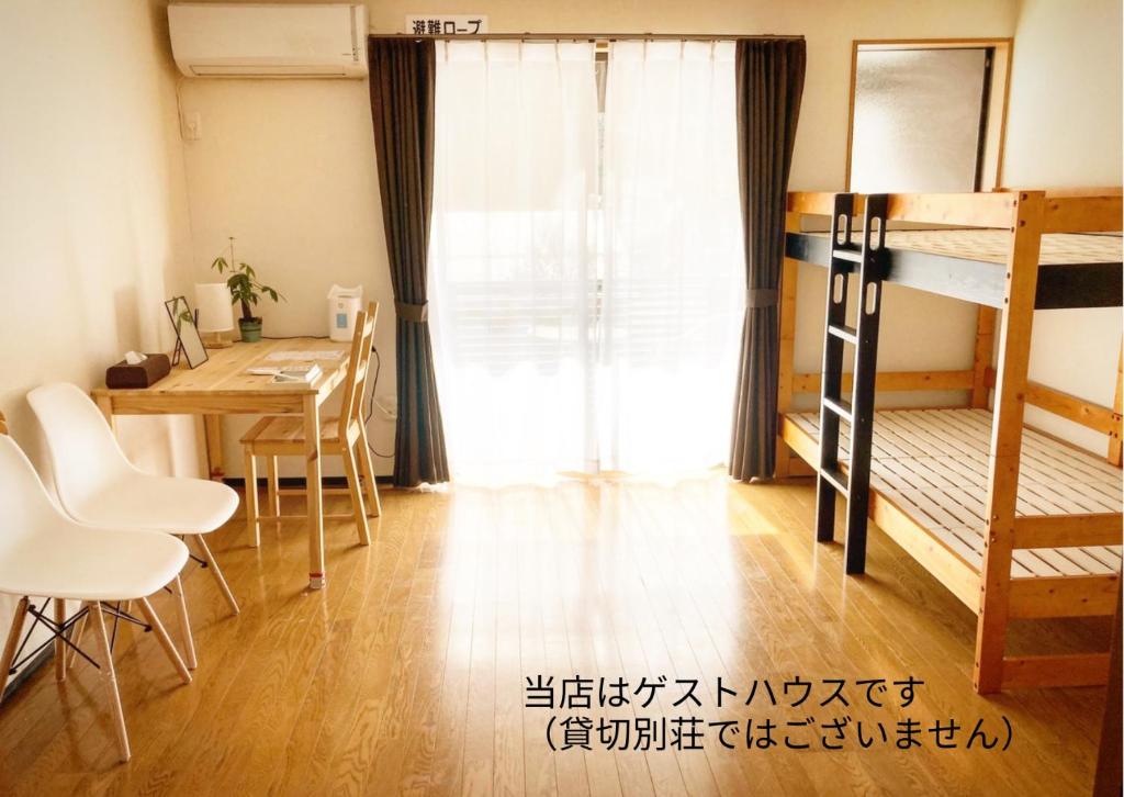a room with a desk and a table and a bunk bed at Private guest house with veranda without bath and shower - Vacation STAY 47236v in Toyooka