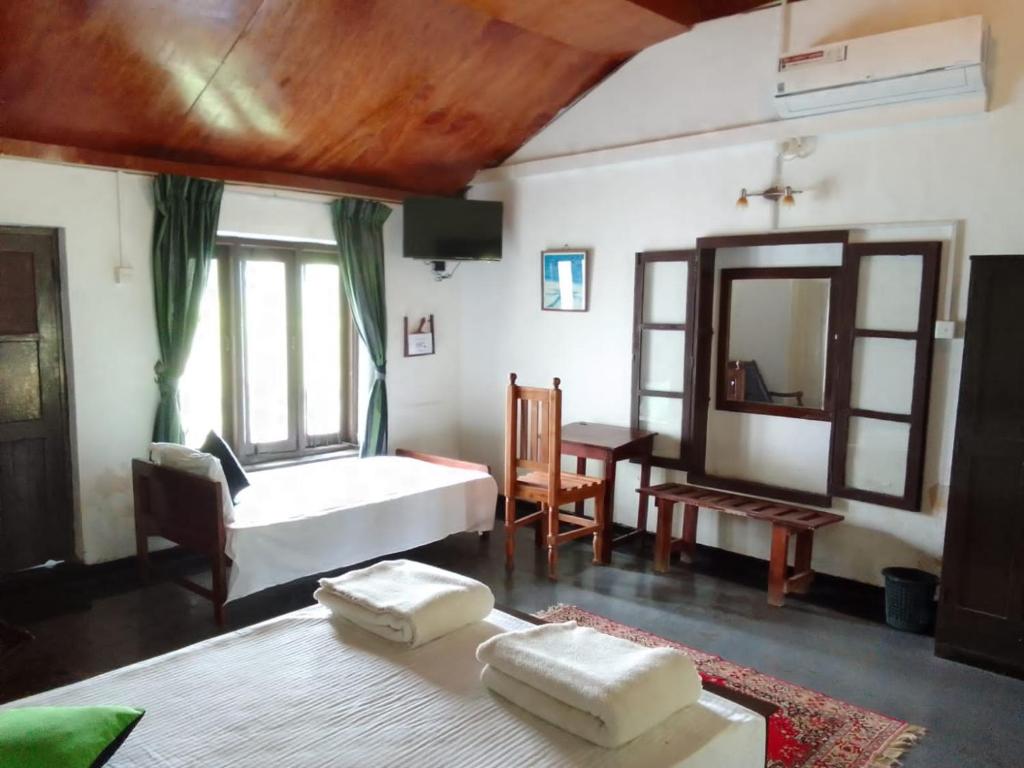 Arachiwil Green Nature Resort في بوتالام: غرفة نوم بسرير ابيض ومرآة