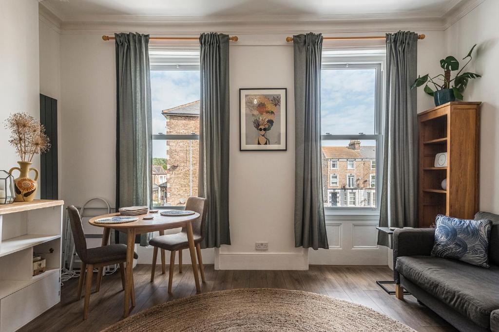 una sala de estar con una mesa y un sofá en Rock Pool Reach - central location with parking, en Broadstairs