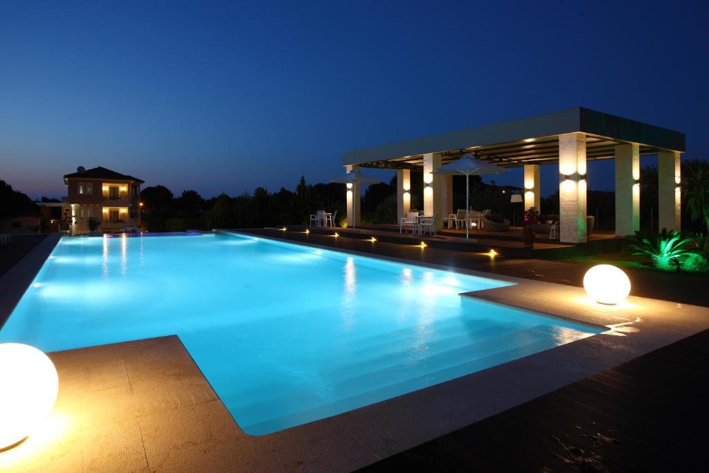 a large swimming pool in front of a building at night at Fillis House in Vourvourou