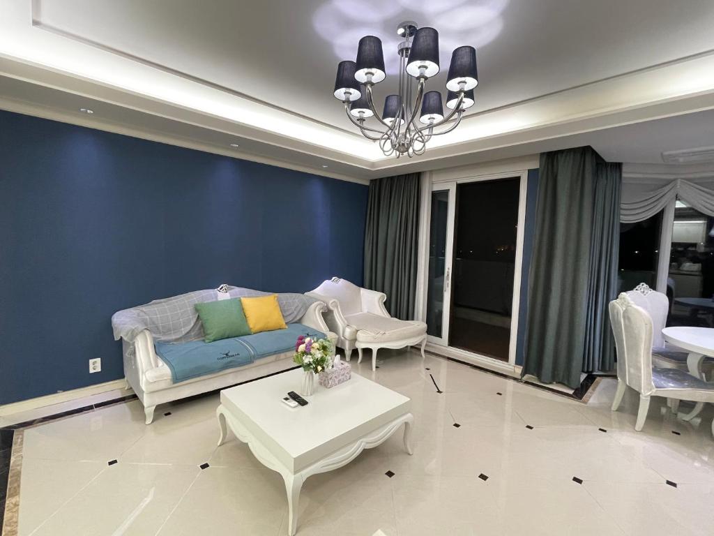 ein Wohnzimmer mit einer Couch und einem Tisch und Stühlen in der Unterkunft Ocean Star Resorts - Seopjikoji in Seogwipo