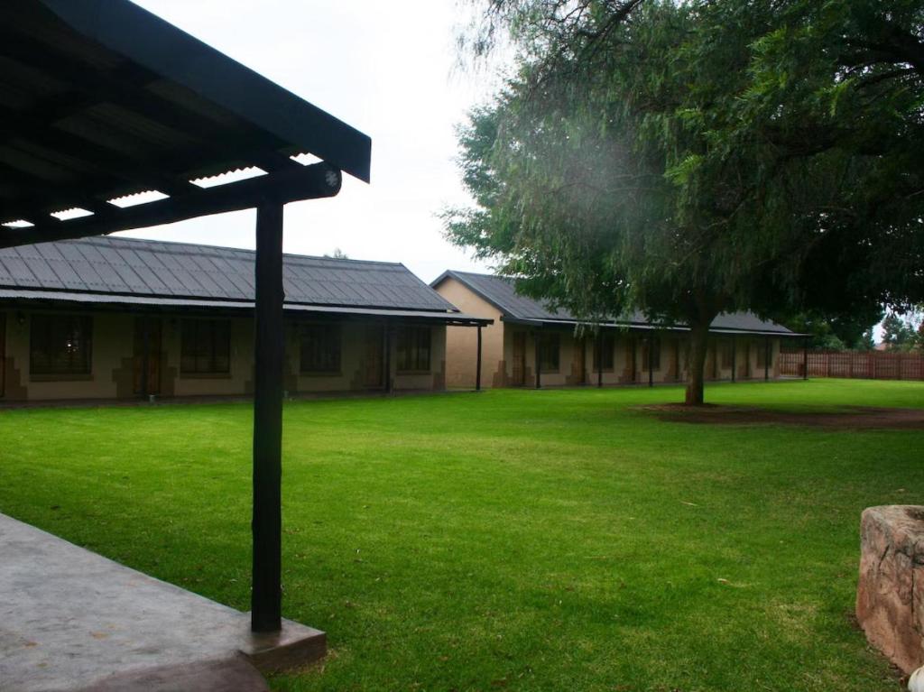 um edifício com um pátio verde com uma árvore em Eastwoods Lodge em Springs