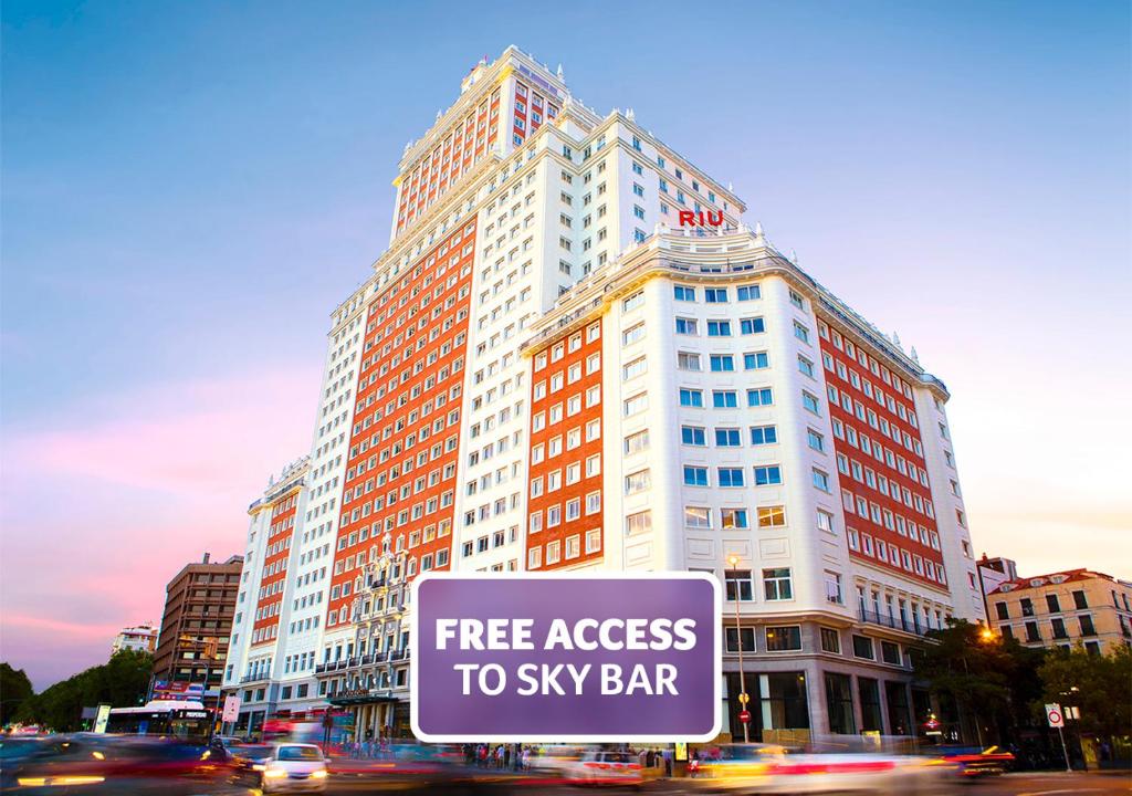 ein großes Gebäude mit kostenfreiem Zugang zum Sky-Bar-Schild in der Unterkunft Riu Plaza España in Madrid