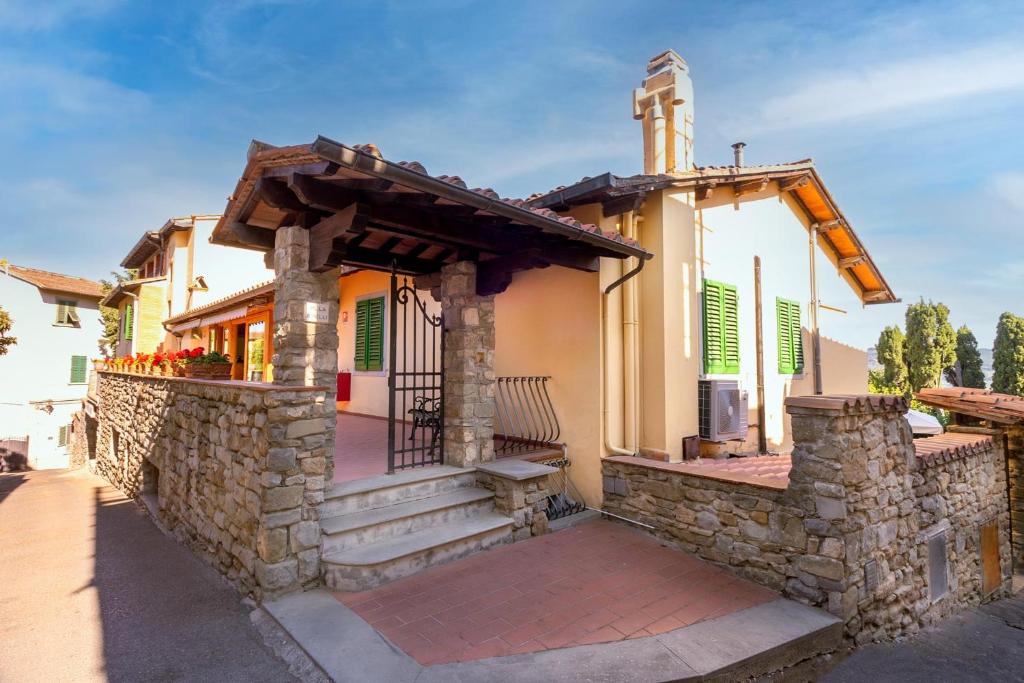 a church building with a stone wall and a porch at Hotel Villa Bonelli in Fiesole