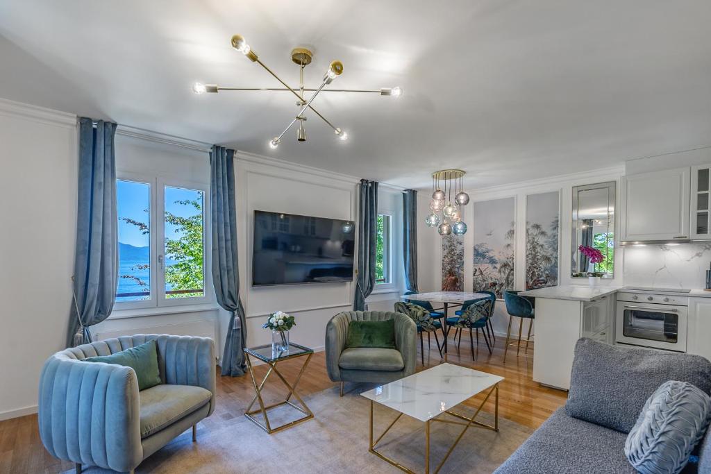 een woonkamer met een bank, stoelen en een tafel bij Soft Glam 1-bedroom appt - Lake & Mountain View in Montreux