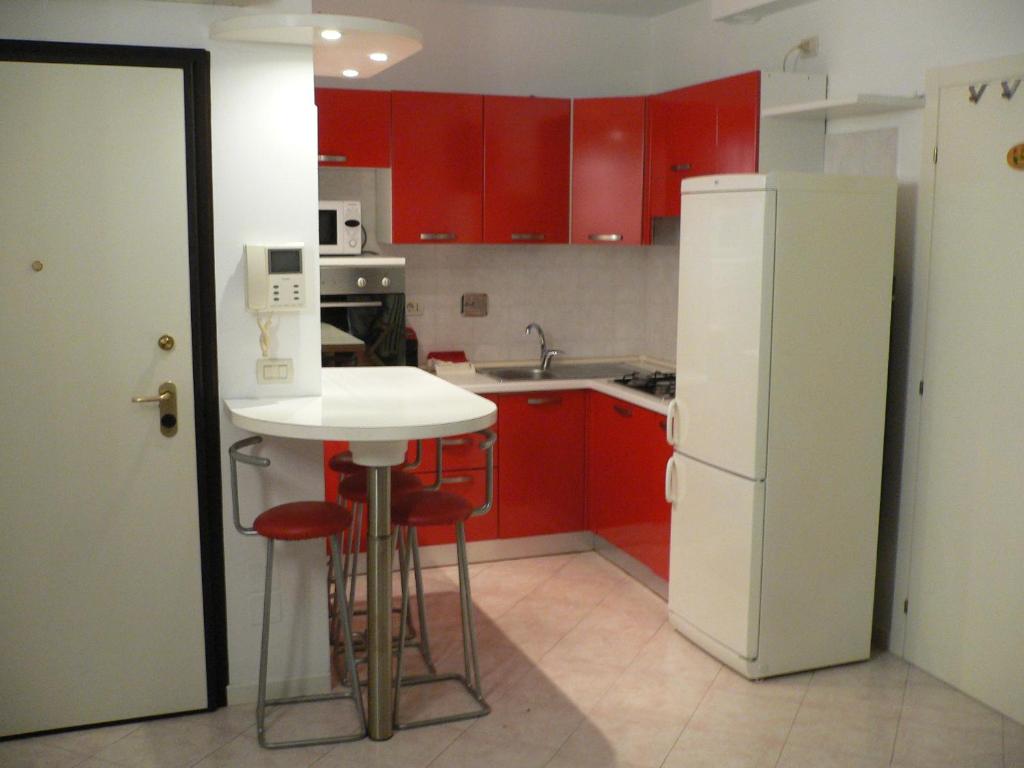 eine Küche mit roten Schränken und einem weißen Kühlschrank in der Unterkunft STOP&GO STATION BOLOGNA house self check-in Stazione AV- FIERA in Bologna