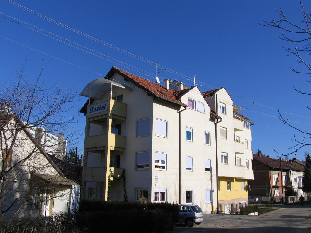 a large white building with a car parked next to it at Apartments and rooms with WiFi Zagreb - 15959 in Zagreb