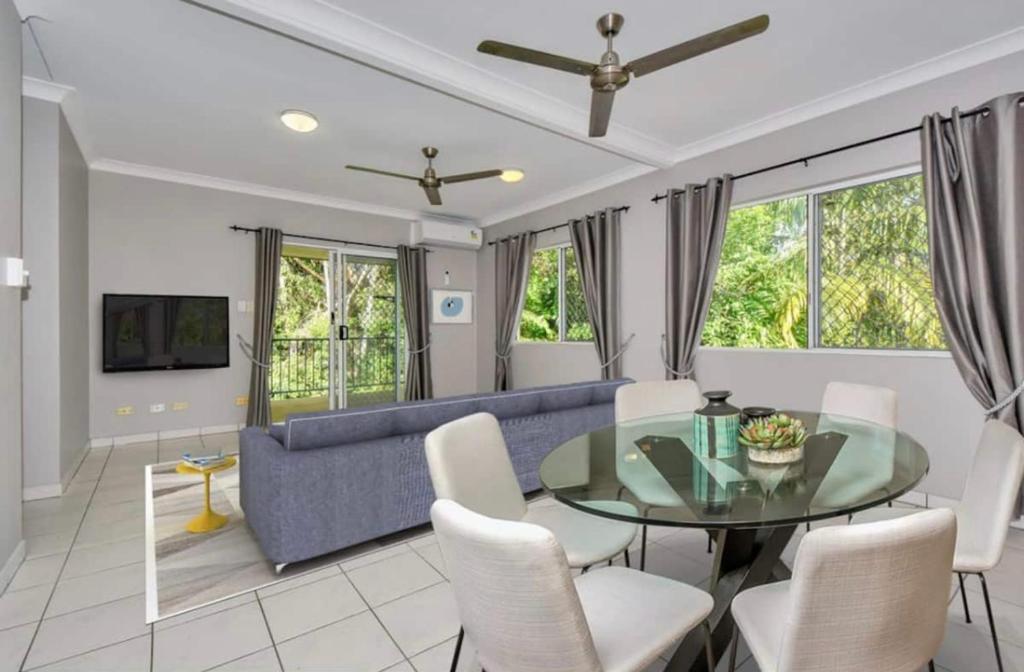 - un salon avec une table en verre et un canapé bleu dans l'établissement The Palms 3 bedroom comfort in quiet court, à Darwin