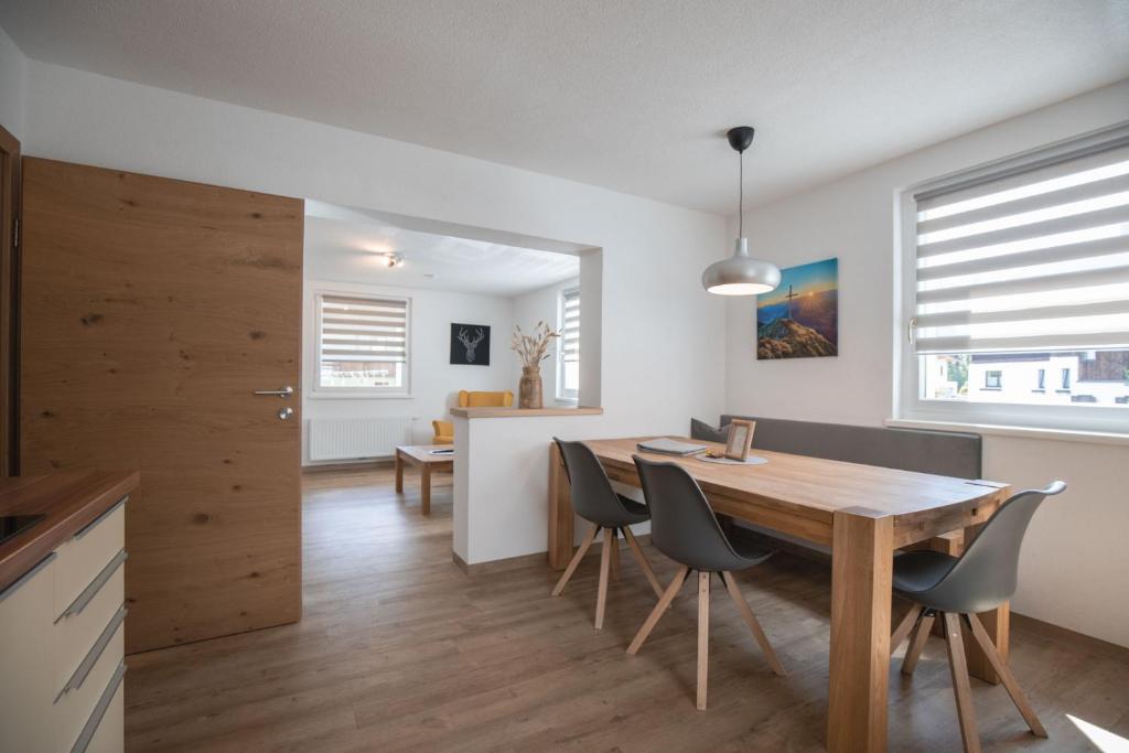 uma cozinha e sala de jantar com uma mesa de madeira e cadeiras em Apart Alp Line em Mils bei Imst