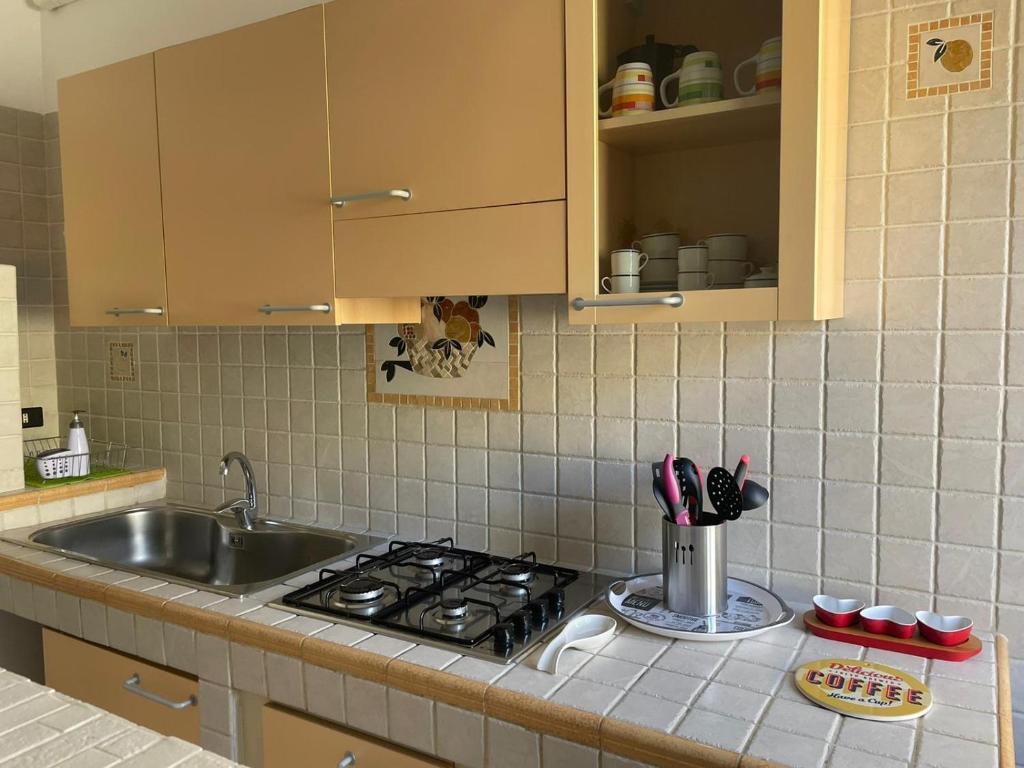 um balcão de cozinha com um fogão e um lavatório em Parvis home em Brindisi