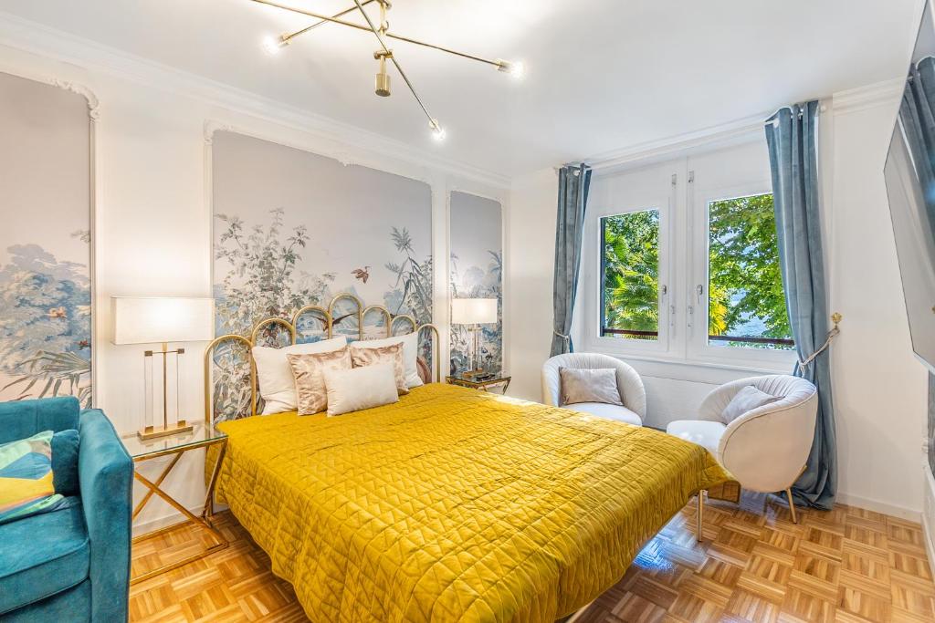 um quarto com uma cama amarela e 2 cadeiras em Secret Garden studio – Lakefront em Montreux