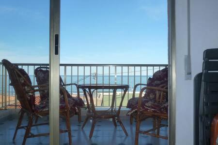 balcón con mesa, sillas y vistas al océano en Rodafam, en Playa de Miramar