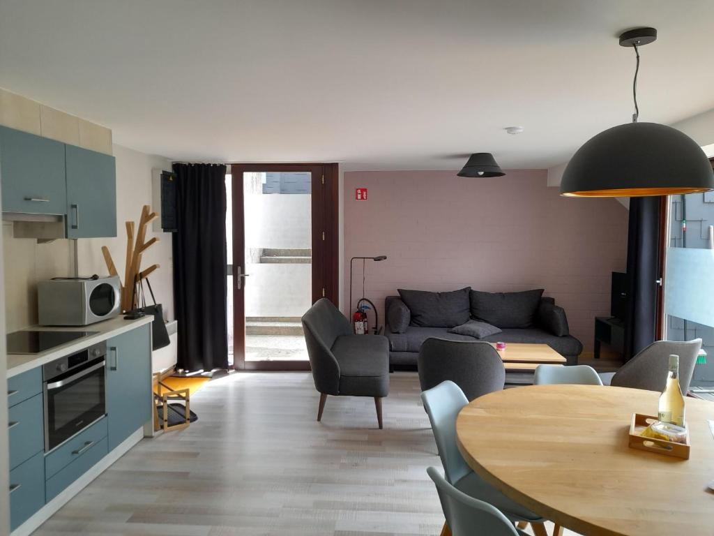 uma cozinha e sala de estar com uma mesa e um sofá em Bord de lac - 4/6pers SAUNA - terrasse 20m2 em Vielsalm