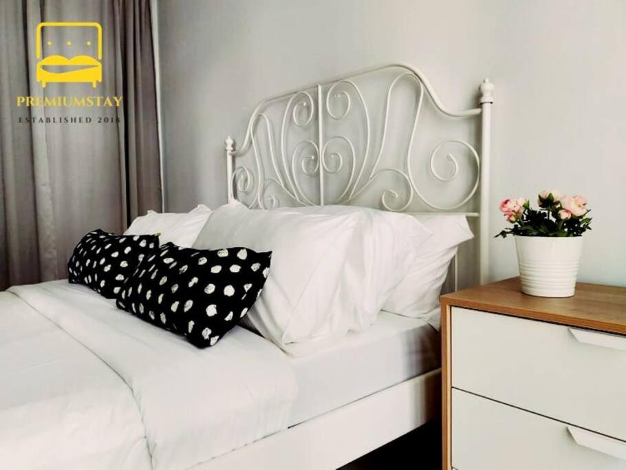 - un lit blanc avec des oreillers en noir et blanc dans l'établissement H2O Retreat Studio Home 5min to LRT by Premium Stay, à Petaling Jaya
