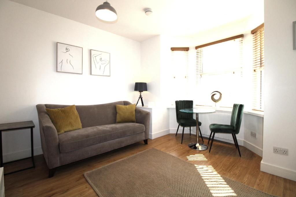 ein Wohnzimmer mit einem Sofa und einem Tisch in der Unterkunft Corbiere House @ Short Stays in Basingstoke