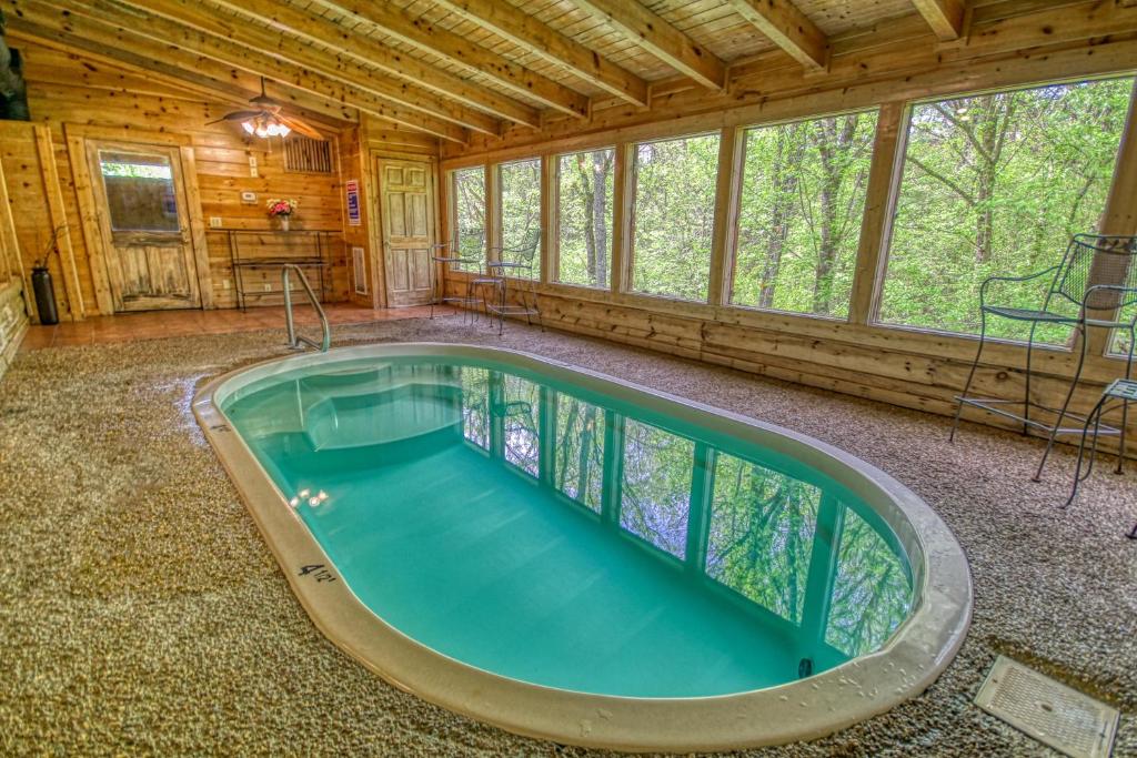 a large indoor pool in a log cabin with a ceiling at Gone Swimmin' #260 in Pigeon Forge