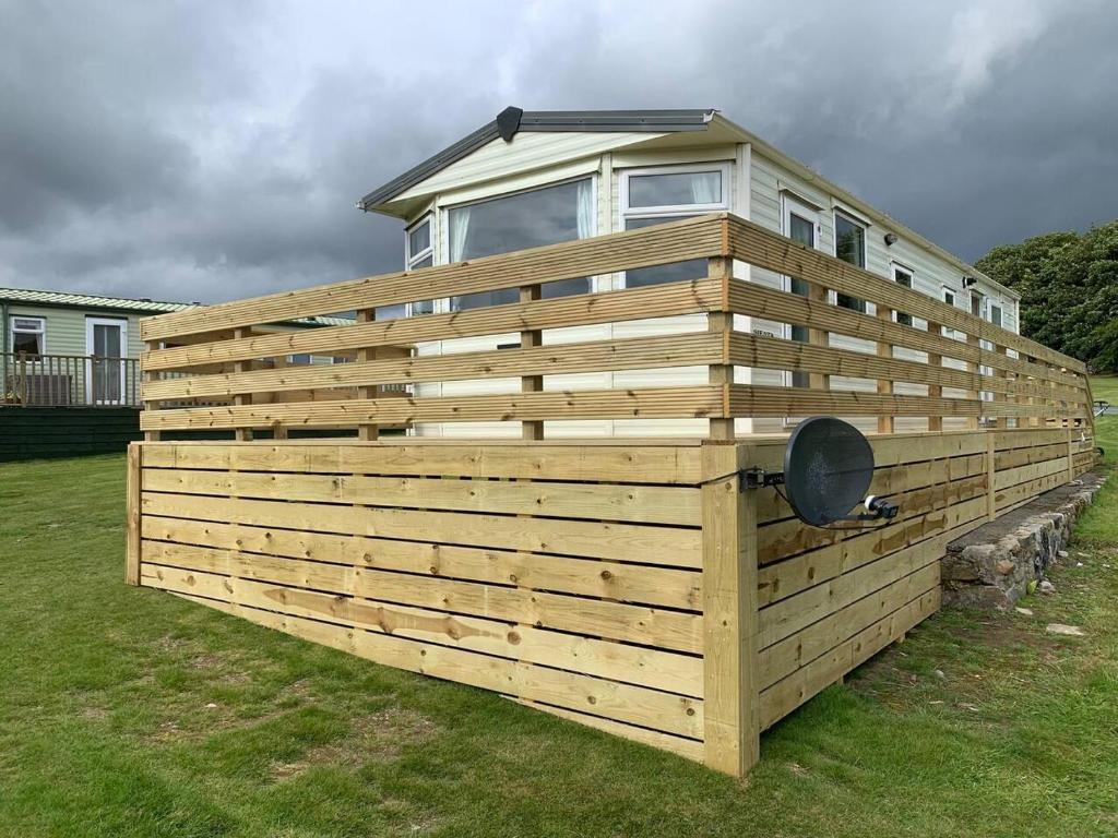 a large wooden fence with a house on top of it at Stunning 2-Bed Apartment in Newton Stewart in Newton Stewart