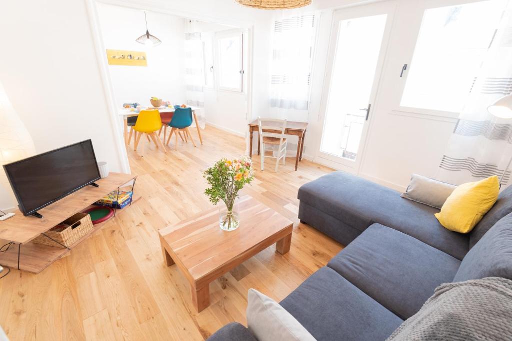 - un salon avec un canapé bleu et une table dans l'établissement Appartement Cosy et Lumineux - Tout équipé - Hypercentre Lorient par Groom, à Lorient