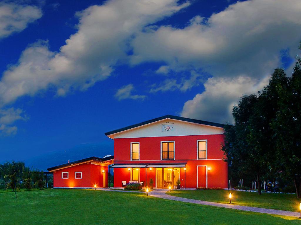 una casa roja con luces en el costado. en Agriturismo la Chiocciola, en Sacile