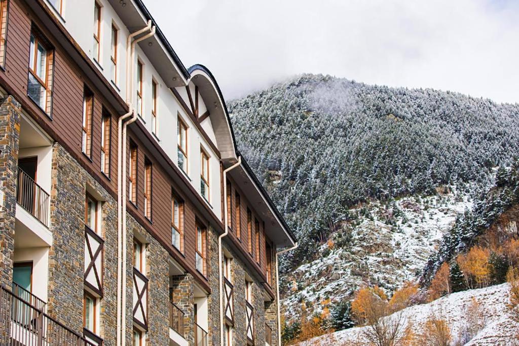 a building with a snowy mountain in the background at The Lodge at Ribasol in Arinsal