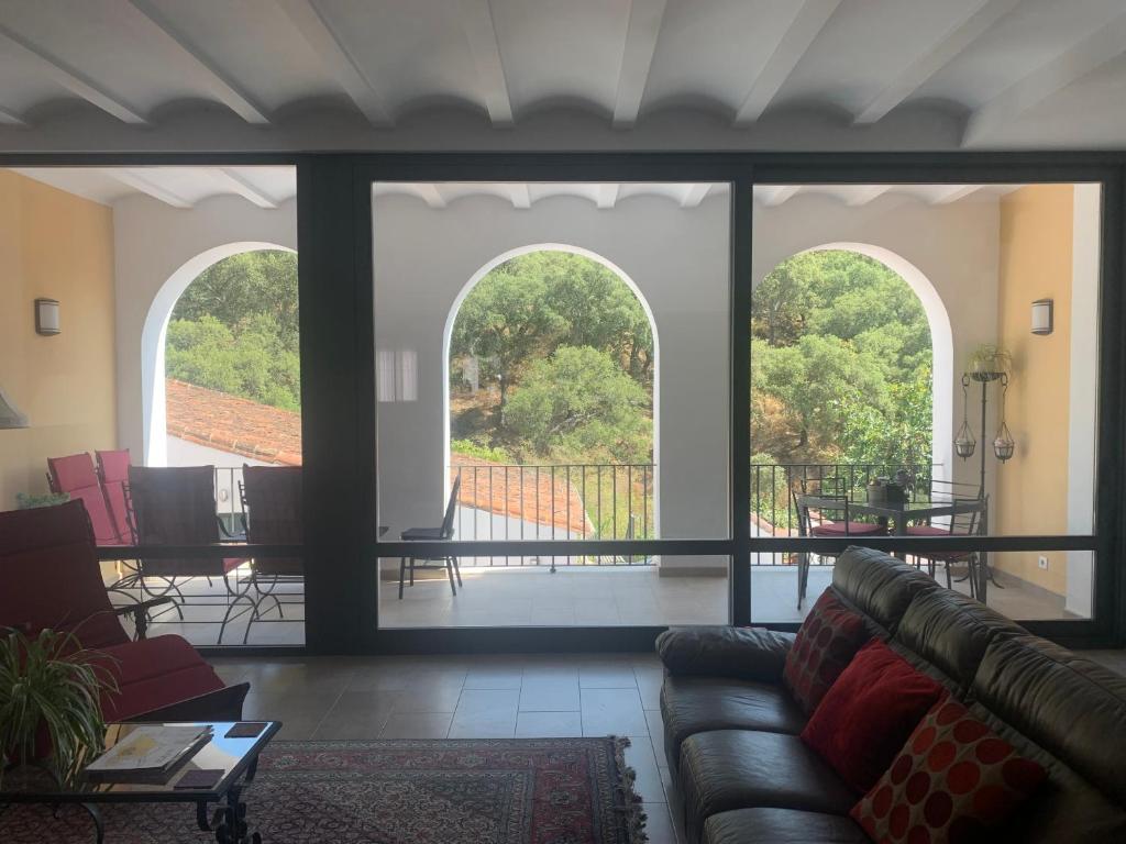 uma sala de estar com duas janelas arqueadas e um sofá em Casa Carmen em Alájar