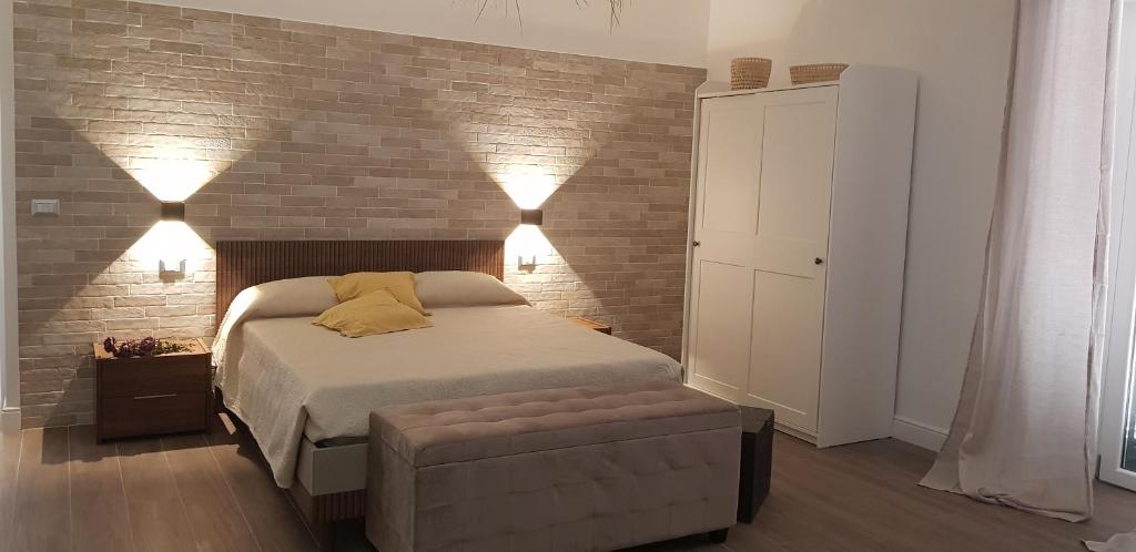 1 dormitorio con cama y pared de ladrillo en Casa Rosamari - su Lago di Posta Fibreno, Appartamento con camino, en Posta Fibreno