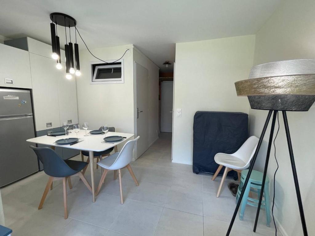 une cuisine avec une table et des chaises dans une pièce dans l'établissement Studio Cabine à 400m de la Plage, Rénové, Clim, Parking, 4 Couchages, TV, Lave-linge, Lave-vaisselle - FR-1-225-679, à Argelès-sur-Mer