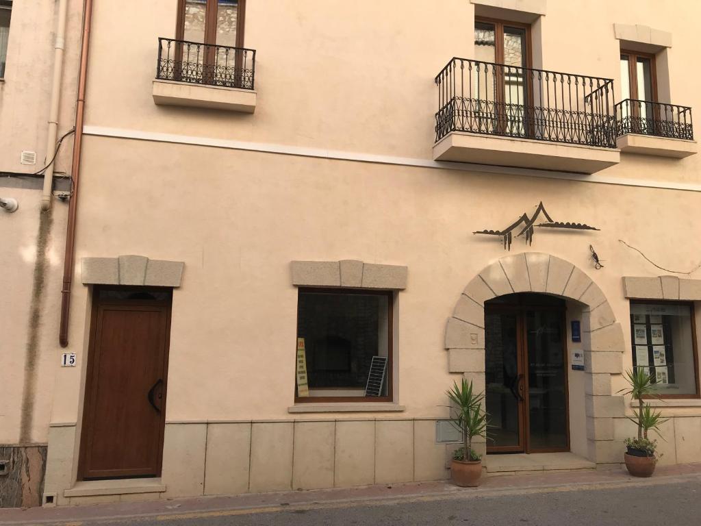 un edificio con dos puertas y dos balcones. en Spacious loft in El Perelló, en Perelló