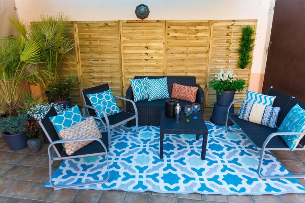 a patio with chairs and a table on a rug at Casa Rural La Pinta- SendaViva y Bardenas in Villafranca