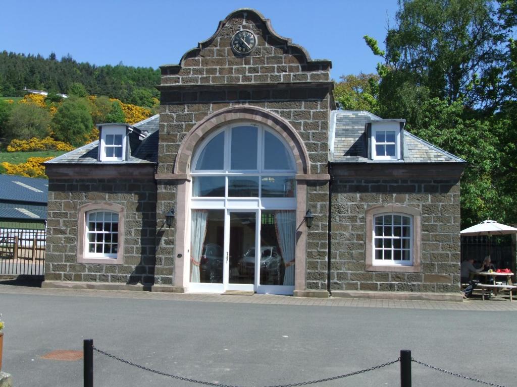 a stone building with a clock on top of it at The Towerview Coach Houses in Perth